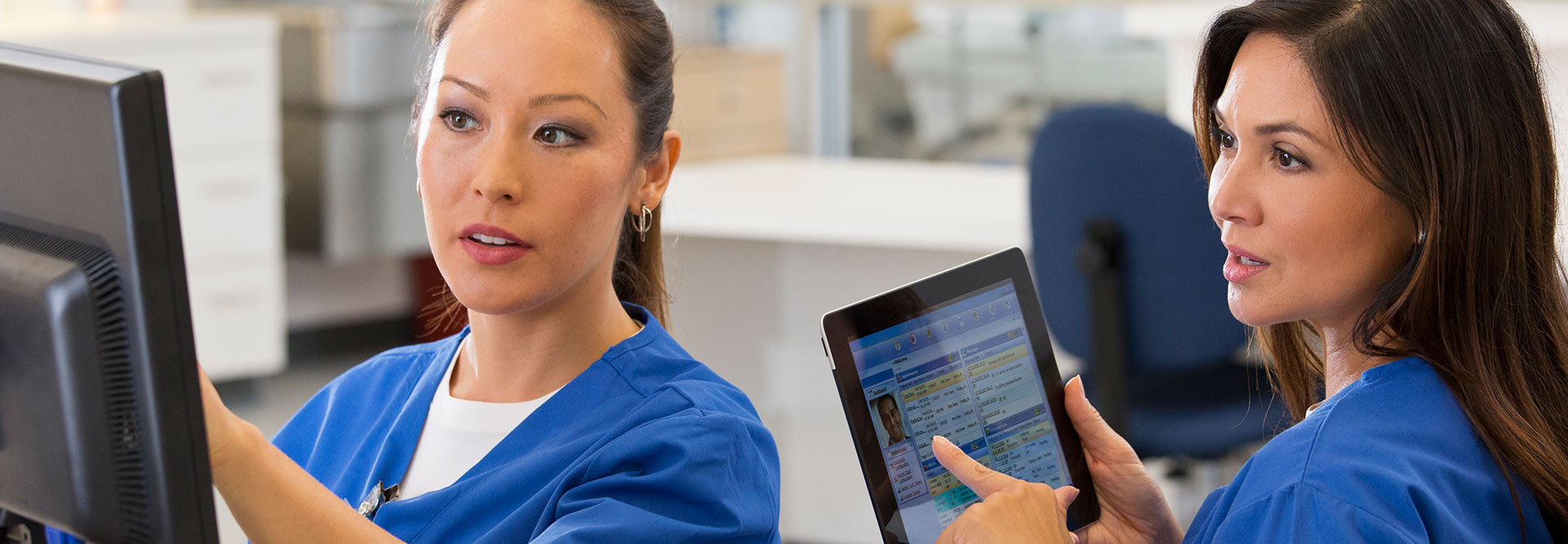 Nurses looking at computer and tablet